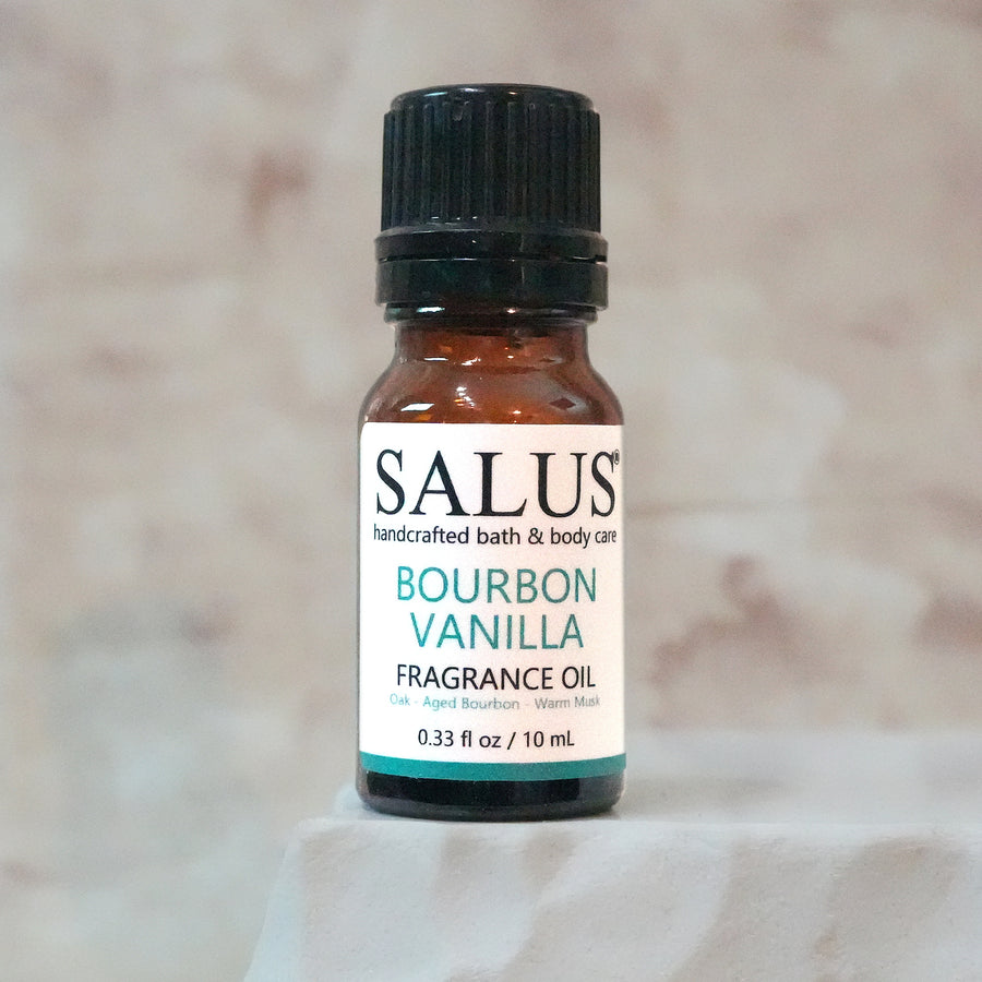 SALUS Bourbon Vanilla fragrance oil, 10 mL amber bottle on a white stone pedestal.