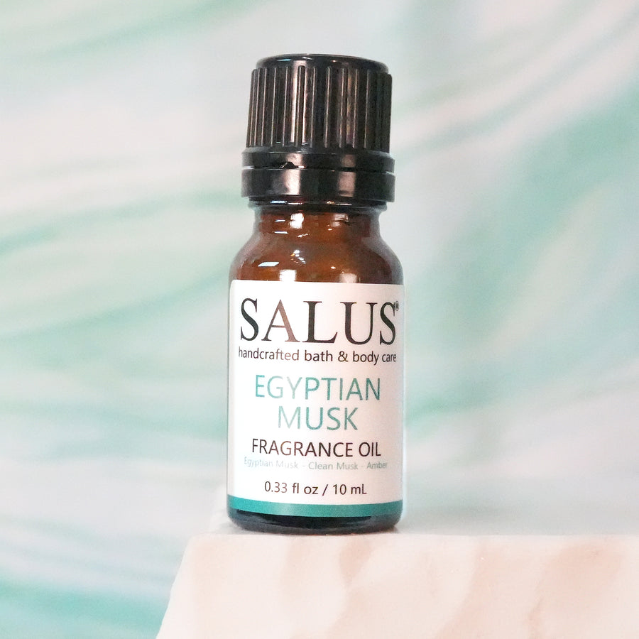 SALUS Egyptian Musk fragrance oil, 10 mL amber bottle on a white stone pedestal.