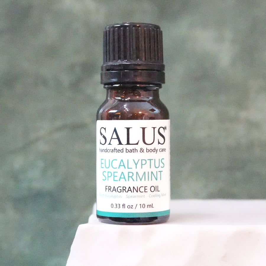 SALUS Eucalyptus Spearmint fragrance oil, 10 mL amber bottle on a white stone pedestal.