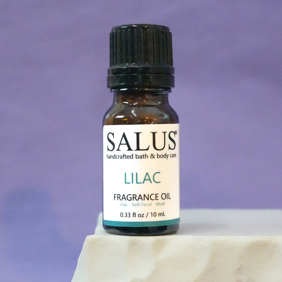 SALUS Lilac fragrance oil, 10 mL amber bottle on a white stone pedestal.
