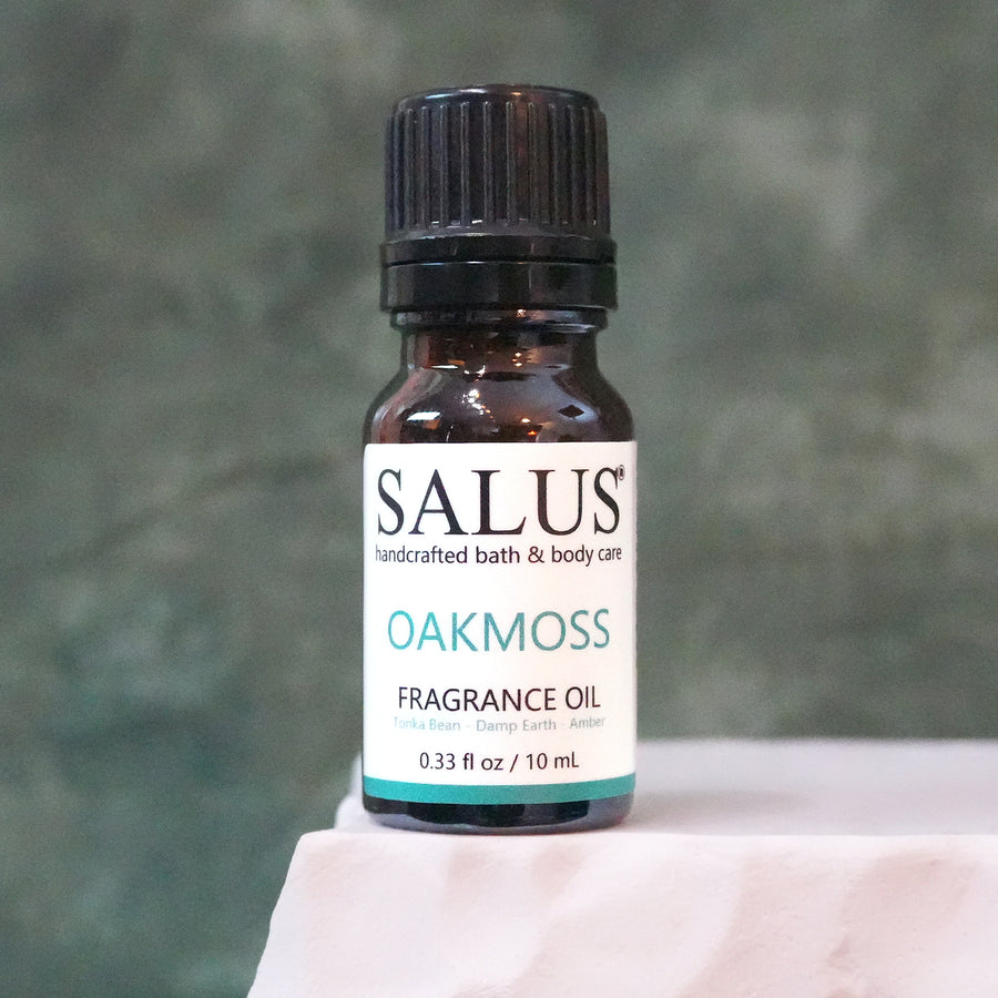 SALUS Oakmoss fragrance oil, 10 mL amber bottle on a white stone pedestal.