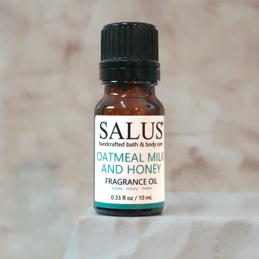 SALUS Oatmeal Milk and Honey fragrance oil, 10 mL amber bottle on a white stone pedestal.