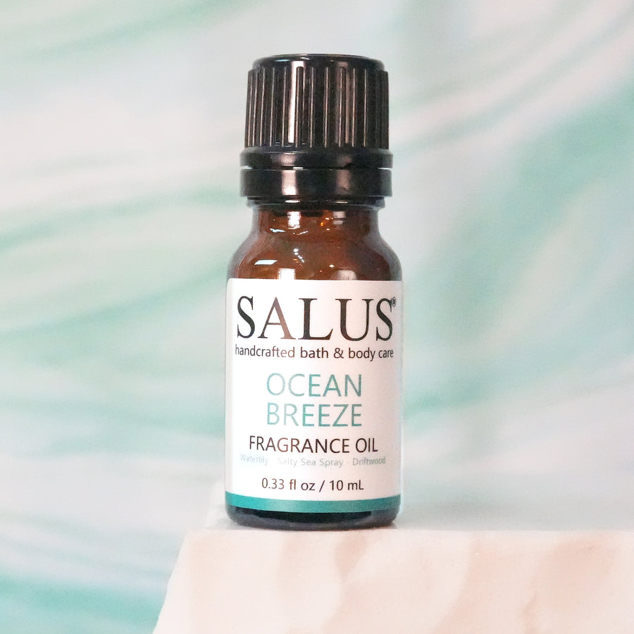 SALUS Ocean Breeze fragrance oil, 10 mL amber bottle on a white stone pedestal.