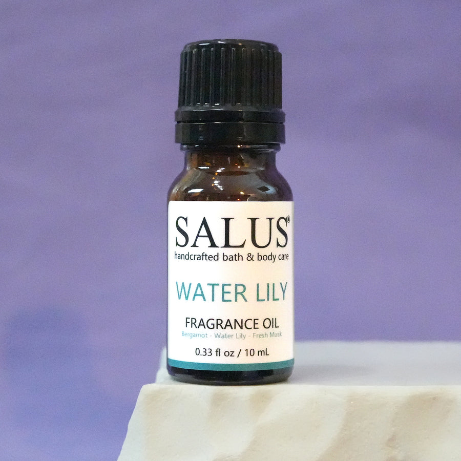 SALUS Water Lily fragrance oil, 10 mL amber bottle on a white stone pedestal.
